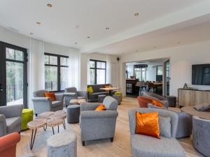 - un salon avec des canapés, des tables et des fenêtres dans l'établissement Villa Col 38, à Kluisbergen