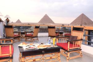 un tavolo con cibo su un balcone con vista sulle piramidi di Pyramids Nun INN a Il Cairo