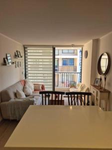 uma sala de estar com um sofá e uma mesa em Habitación con Baño Privado en Depto Compartido em Santiago