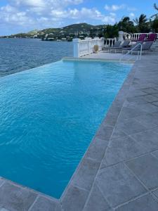 a large blue swimming pool next to a body of water at MIRAMAR in Christiansted +16 photos