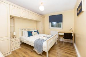 a bedroom with a white bed and a desk at Magnificent 3BR Apt wPrivate Garden, Angel in London