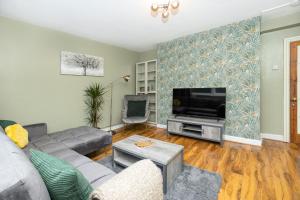 uma sala de estar com um sofá e uma televisão em Magnificent 3BR Apt wPrivate Garden, Angel em Londres