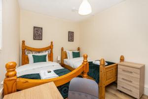 a bedroom with two twin beds and a desk at Magnificent 3BR Apt wPrivate Garden, Angel in London