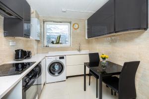 a kitchen with a washing machine and a table with chairs at Magnificent 3BR Apt wPrivate Garden, Angel in London