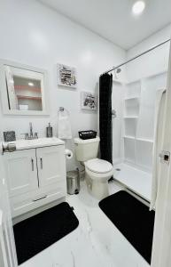 a white bathroom with a toilet and a shower at Luxury Studio only 5 miles to IAH in Humble