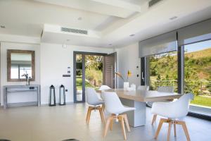 a dining room with a table and white chairs at Christina by Vintage Travel in Spartia