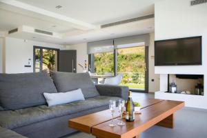 a living room with a couch and a table with wine glasses at Christina by Vintage Travel in Spartia
