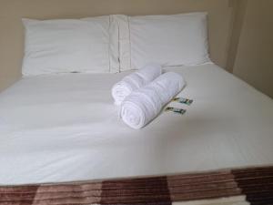 a bed with three rolled up towels on it at Casa de hóspedes em Capão Bonito c/ Wi-Fi in Capão Bonito