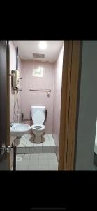 a bathroom with a toilet and a sink at Hotel Iramanis in Lahad Datu