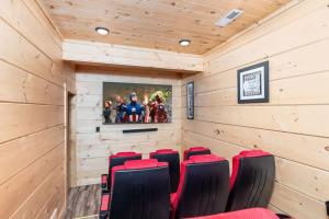 a movie room with red chairs and a tv at Stunning Sevierville Cabin: Hot Tub w/ View in Sevierville