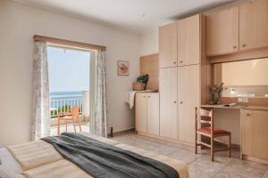 a bedroom with a bed and a kitchen with a balcony at Villa Angeliki Skala in Spathíon