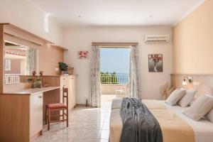 a bedroom with two beds and a kitchen with a view at Villa Angeliki Skala in Spathíon