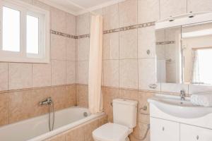 a bathroom with a toilet and a tub and a sink at Villa Angeliki Skala in Spathíon +27 photos