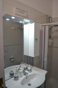 een badkamer met een witte wastafel en een spiegel bij Horizon in Castel San Giorgio