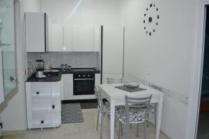 a white kitchen with a white table and chairs at Horizon in Castel San Giorgio