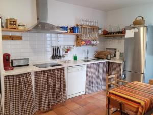 a kitchen with a sink and a refrigerator at Amapola Alojamiento Rural in Zuheros