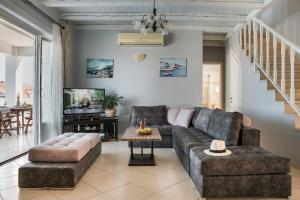 a living room with a couch and a tv at Evanthia by Vintage Travel in Fiskardo