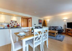 cocina y sala de estar con mesa y sillas en 14 Neptune House en Milford Haven