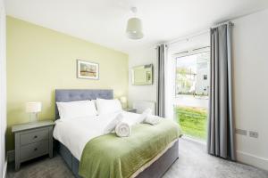 une chambre avec un lit et une grande fenêtre dans l'établissement Luxury property with spa access on a nature reserve Damselfly HM105, à Somerford Keynes 16 autres photos