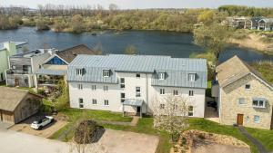 une vue aérienne d'une maison avec un lac dans l'établissement Luxury property with spa access on a nature reserve Damselfly HM105, à Somerford Keynes