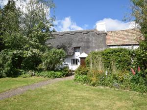 een wit huis met een zwart dak en een tuin bij 2 Bed in St Neots 62322 in Wyboston