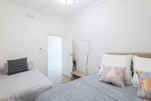 ein weißes Schlafzimmer mit 2 Betten und einem Spiegel in der Unterkunft Waterfront - KING Bed Master @ Rocks Sydney #9A in Sydney