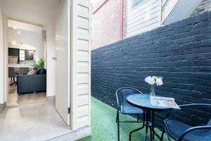 a patio with a table and chairs next to a brick wall at Waterfront - KING Bed Master @ Rocks Sydney #9A in Sydney