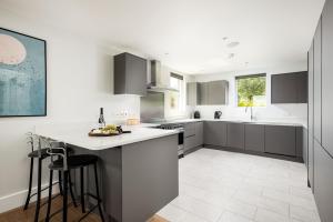 uma cozinha com balcões brancos e uma bancada em Lakeside property with spa access on a nature reserve Keel House CW23 em Somerford Keynes