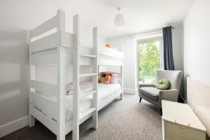 - une chambre avec des lits superposés blancs et une chaise dans l'établissement Lakeside property with spa access on a nature reserve Keel House CW23, à Somerford Keynes 18 autres photos