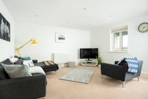 un salon avec deux canapés et une télévision dans l'établissement Lakeside apartment with spa access on a nature reserve Hazy Blue HM86, à Somerford Keynes