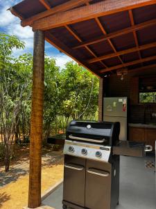 an outdoor kitchen with a grill under a pergola at Sertão do Luar in Jurubeba