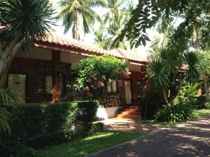 a house with palm trees in front of it at Ban Krut Resort in Ban Krut