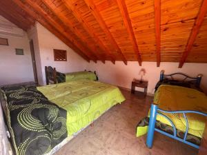ein Schlafzimmer mit zwei Betten und einer Holzdecke in der Unterkunft Aires del Oeste - Casa de Descanso in Villa Unión