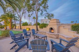 - un groupe de chaises bleues, une table et une cheminée dans l'établissement Scottsdale Vacation Rentals, à Scottsdale