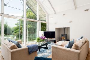 un salon avec deux canapés et une télévision dans l'établissement Lakeside property with spa access on a nature reserve Kingfisher Lodge CW80, à Somerford Keynes