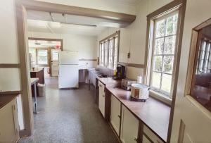 a large kitchen with a white refrigerator and windows at Large Lodge at Rainier Lodge (0.4 miles from entrance) in Ashford