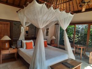 1 dormitorio con 1 cama con dosel en Nefatari Exclusive Villas, en Ubud