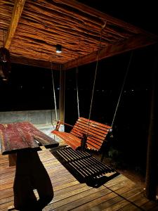 Sertão do Luar في Jurubeba: شرفة خشبية مع أرجوحة على السطح