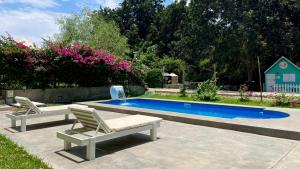 a swimming pool with two lounge chairs next to it at Serenity hotel & lodge in Ica