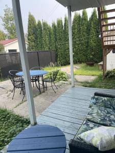eine Terrasse mit einem Tisch und Stühlen sowie einem Picknicktisch in der Unterkunft 4 Pièces, stationnement et tennis in Saguenay