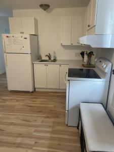 uma cozinha com electrodomésticos brancos e um frigorífico branco em 4 Pièces, stationnement et tennis em Saguenay
