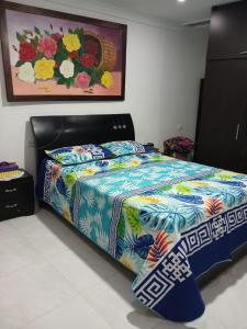 1 dormitorio con 1 cama con un edredón colorido en Alojamiento festival vallenato, en Valledupar