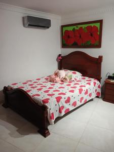 a bedroom with a bed with a teddy bear on it at Alojamiento festival vallenato in Valledupar
