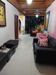 a living room with black leather couches and a table at Alojamiento festival vallenato in Valledupar