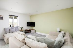 a living room with two couches and a flat screen tv at Lakeview apartment with a Spa on a nature reserve Wigeon HM110 in Somerford Keynes