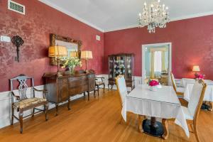 a dining room with red walls and a table and chairs at Grand Mansion-Blue Jay suite! in Fort Smith