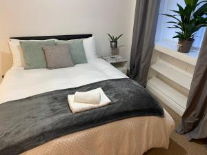 Un dormitorio con una cama grande con una almohada. en A lovely one bed flat in North Finchley, en Finchley