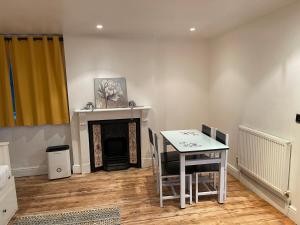 ein Esszimmer mit einem Tisch und einem Kamin in der Unterkunft A lovely one bed flat in North Finchley in Finchley