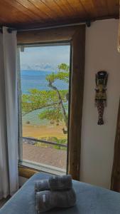 um quarto com uma janela com vista para o oceano em Pousada Belas Águas em Praia de Araçatiba