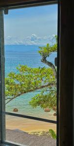 uma vista para o oceano a partir de uma janela em Pousada Belas Águas em Praia de Araçatiba